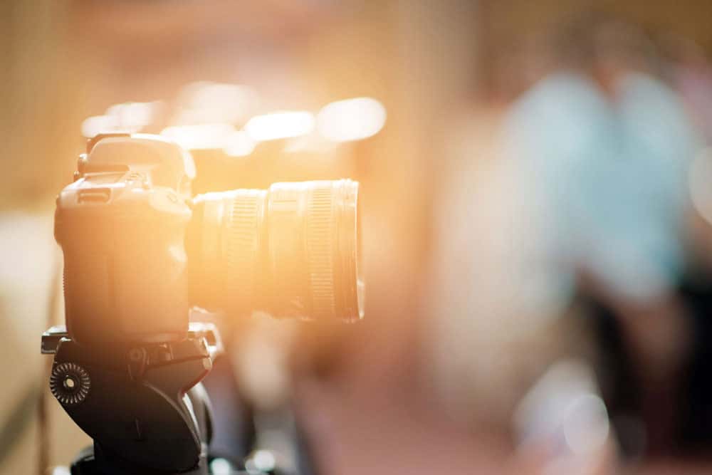videography equipment on a stand, with blurred people in the background